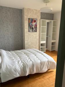 a bedroom with a white bed in a room at Gambetta in Rethel