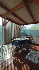 a wooden deck with a table and chairs on it at Villa MegaLit - відпочинок у котеджах з чанами біля Косино та Берегово in Velyka Bihanʼ