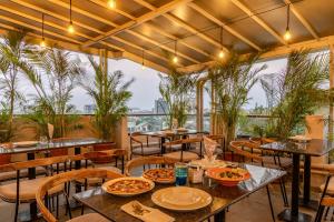 a restaurant with tables and chairs and plants at Hotel Tattva Suites NIBM, next to Corinthians Club in Pune