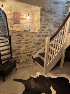 a room with a staircase and a chair next to a wall at Karja Castle Apartments in Haapsalu