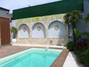 a swimming pool in front of a building with arches at Sunnyside cottage Bilgah in Bilgah