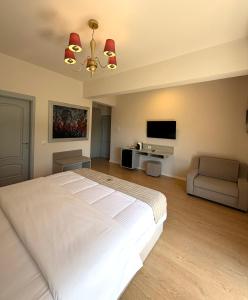 a bedroom with a large white bed and a flat screen tv at Illyrian Boutique Hotel in Sarandë