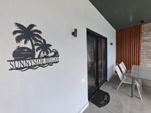 a sign on a wall with a palm tree on it at Sunnyside cottage Bilgah in Bilgah