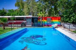 a fire truck parked next to a pool with a snake painted on it at Hostel Lemon Tree in Ciudad Lujan de Cuyo
