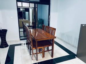 a wooden table and chairs in a room at The Gateway Luxury Apartment in Kigali