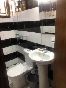 a bathroom with a toilet and a sink at The Gateway Luxury Apartment in Kigali