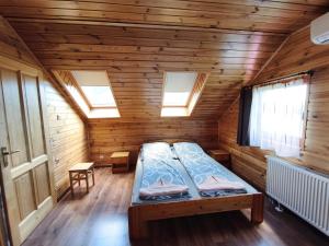 a room with a bed in a wooden room at Vili Vendégház in Demjén
