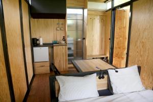 a room with a bed with two pillows and a kitchen at IRON Cabin in Gaylyunay