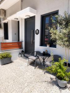 a house with a black door and a table and chairs at DS Elegant Apartment in Ermoupoli