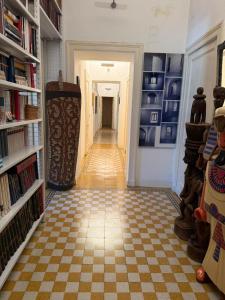 a hallway with a checkered floor and bookshelves at Centro - doppia in casa d'artista in Turin