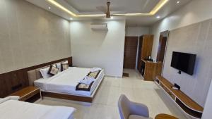 a hotel room with a bed and a tv at Hotel Akshara Inn in Nasīrābād