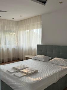 a bedroom with a bed with two towels on it at Vila cu Ciubar & Jacuzzi - Sunset Hill House in Cuvin +46 photos