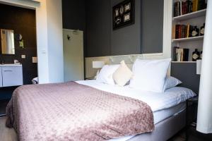 a bedroom with a large bed with white pillows at Hotel La Tonnellerie in Spa