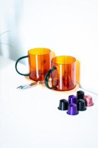 two orange and yellow coffee mugs on a shelf at Hotel La Tonnellerie in Spa