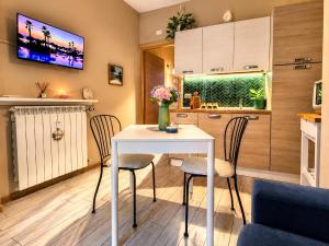 a kitchen and dining room with a white table and chairs at Aloha Pool Apartment - Free Parking - Sirmione in Desenzano del Garda