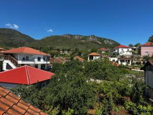 a group of houses with mountains in the background at Double Triple Rooms With Lake View balcony in Pogradec