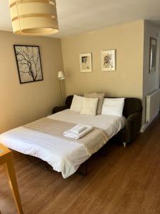 a bedroom with a large bed with white sheets at The Granary, Wonderful Riverside Accommodation in Bodenham
