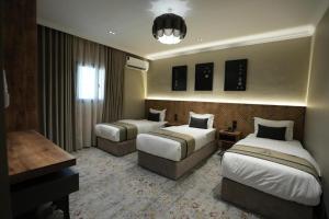 a hotel room with two beds and a desk at فندق اناف in Medina +207 photos