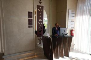 a man standing at a desk in a room with a computer at فندق اناف in Medina