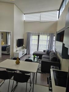 a living room with a couch and a table at Beautiful 2 bedroom unit, inverter & complex pool in Johannesburg