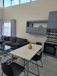 a living room with a white table and chairs at Beautiful 2 bedroom unit, inverter & complex pool in Johannesburg