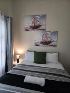 a bedroom with a bed with two paintings of boats at Beautiful 2 bedroom unit, inverter & complex pool in Johannesburg