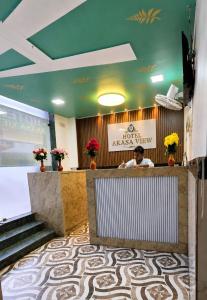 a man sitting at a counter in a hotel lobby at Hotel Akasa View in Mumbai