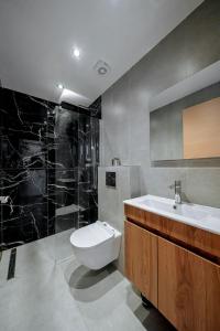 a bathroom with a toilet and a sink at Ambra Luxury Suite 18 in Kallithea Halkidikis +10 photos