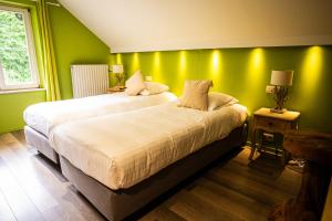 two beds in a room with green walls at Hotel La Tonnellerie in Spa +17 photos
