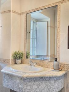 a bathroom with a sink and a large mirror at Apartamentos Turísticos Rosa in Ribadeo +32 photos