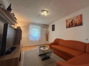 a living room with a couch and a flat screen tv at Kuća BORNA in Crikvenica