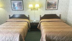 a hotel room with two beds and a desk with lamps at Pleasant Valley Motel West Stockbridge in West Stockbridge