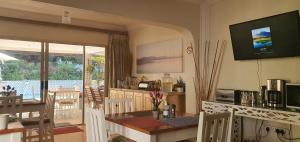 a kitchen with a table and a dining room with a view of a patio at PepperTree Guest House Paulshof Jhb Sandton Solar&Borehole in Johannesburg