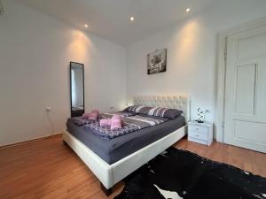 a bedroom with a bed with pink pillows and a mirror at Kuća BORNA in Crikvenica