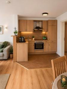 an open kitchen with wooden cabinets and a table at Villa Verde in Flensburg