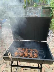 a grill with some meat cooking on it at Beloved Regency Homestay in Kandy