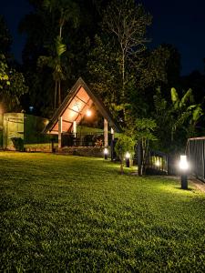 a house with lights on the lawn at night at Beloved Regency Homestay in Kandy