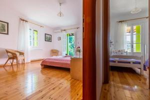 a bedroom with a bed and a desk in a room at Avgeri Villa in Skopelos Town