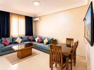 a living room with a couch and a table at Appartement Climatisé 2 Chambres à Marrakech Proche Golf & Jamaâ El Fna in Marrakesh