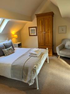 a bedroom with a bed and a chair and a window at The Hayloft, Wonderful Riverside Accommodation in Bodenham