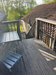 a wooden deck with a bench and a roof at The Hayloft, Wonderful Riverside Accommodation in Bodenham