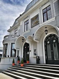 a large white building with stairs in front of it at Angelo Doro Hotel in Ploieşti