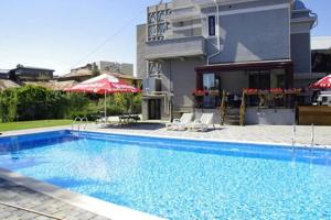 a large swimming pool in front of a house at Angelo Doro Hotel in Ploieşti