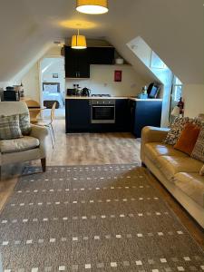 a living room with a couch and a kitchen at The Hayloft, Wonderful Riverside Accommodation in Bodenham +7 photos