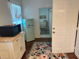 a kitchen with a tv and a refrigerator and a door at Cozy Luxury Cottage in Alachua +5 photos