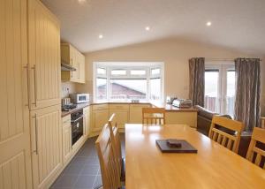 a kitchen with a wooden table and a dining room at Bossiney Bay in Tintagel +110 photos