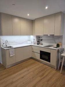 a kitchen with white cabinets and a sink at Brand New - Studio Apartment - Self Catering in Gibraltar