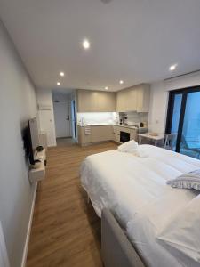 a large bedroom with a large bed and a kitchen at Brand New - Studio Apartment - Self Catering in Gibraltar