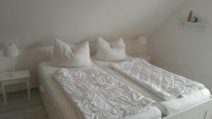 two pillows on top of a bed in a room at 'Seeperle' am Strand des Kummerower Sees in Verchen