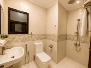 a bathroom with a toilet and a sink at hotel Alsalam suites in Salalah +36 photos